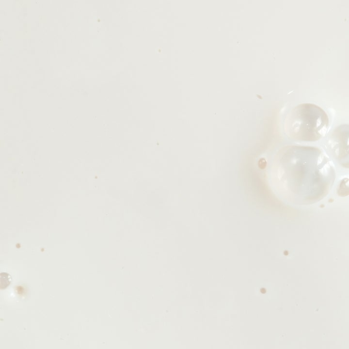 KORA Organics Silky Sun Drops 30 ml mineralbasert solserum har en hvit melkeaktig tekstur med små luftbobler.