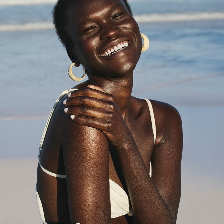 Sol de Janeiro Copacabana Bronze Glow Oil 75 ml kroppsolje gir glød på en smilende kvinne med solbrun hud