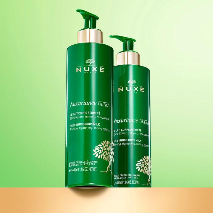 Nuxe Nuxuriance ULTRA The Firming Body Milk 400 ml oppstrammende bodylotion i grønn pumpeflaske ved siden av glatt hud.