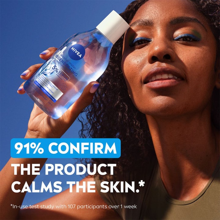 NIVEA Micellar Water Regenerating 400 ml beroligende ansiktsrens i blå flaske holdes av kvinne ute.
