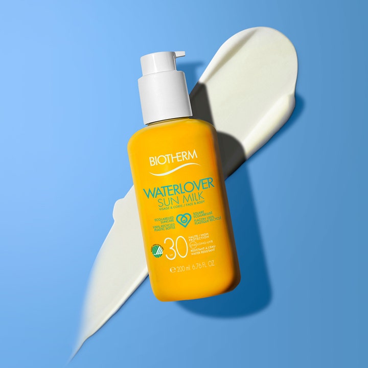 Biotherm Waterlover Sun Milk 200 ml solkrem SPF30 i gul flaske med hvit pumpe plassert over kremet hvit tekstur