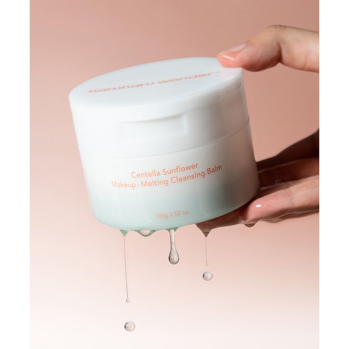 haruharu wonder Centella Sunflower Makeup-Melting Cleansing Balm 100 g hvit krukke som holdes over dryppende dråper