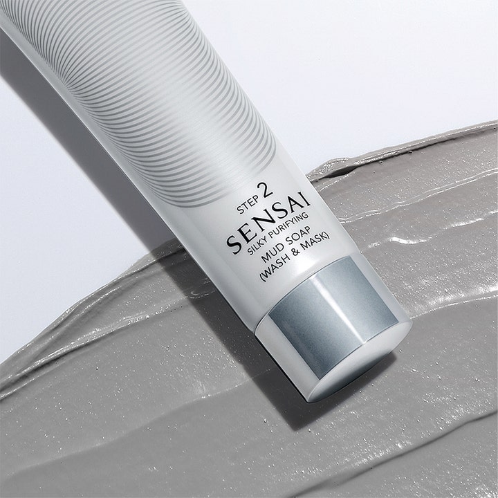 Sensai Silky Purifying Mud Soap Wash & Mask 125 ml ansiktsrens i hvit tube med sølvdetaljer over grå leiretekstur.