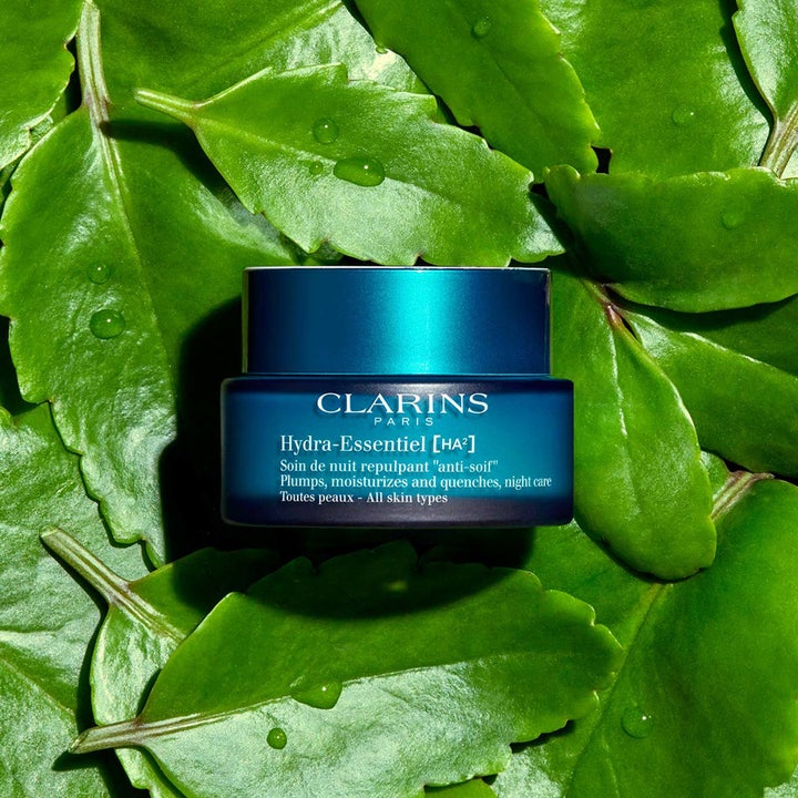 Clarins Hydra-Essentiel 50 ml plumpende nattkrem i mørkeblå krukke omgitt av duggfriske grønne blader.