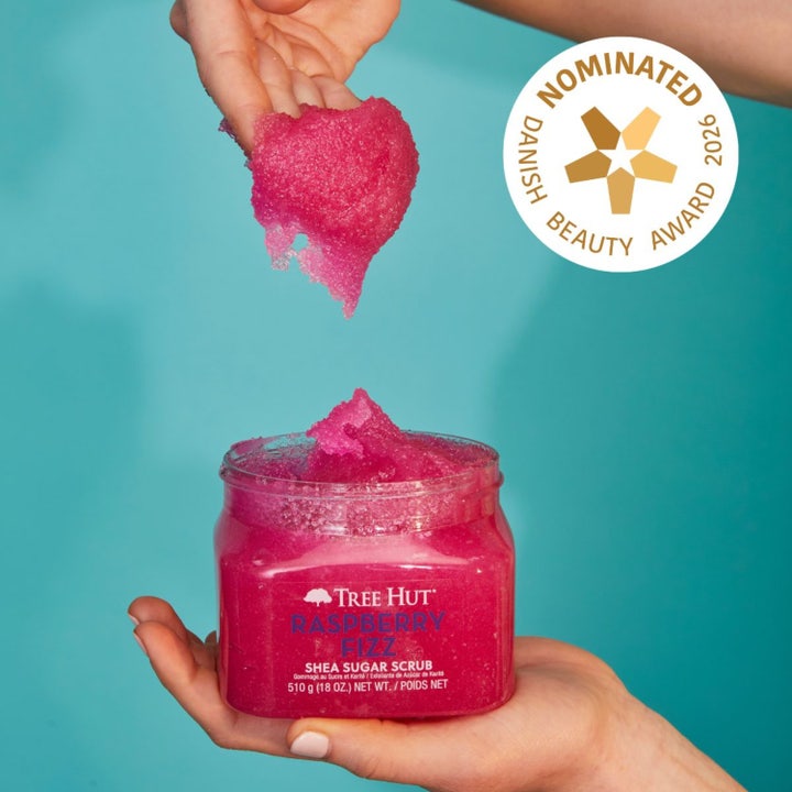 Tree Hut Shea Sugar Scrub Raspberry Fizz 510 g eksfolierende kroppsskrubb med rosa kornat tekstur som løftes fra krukken