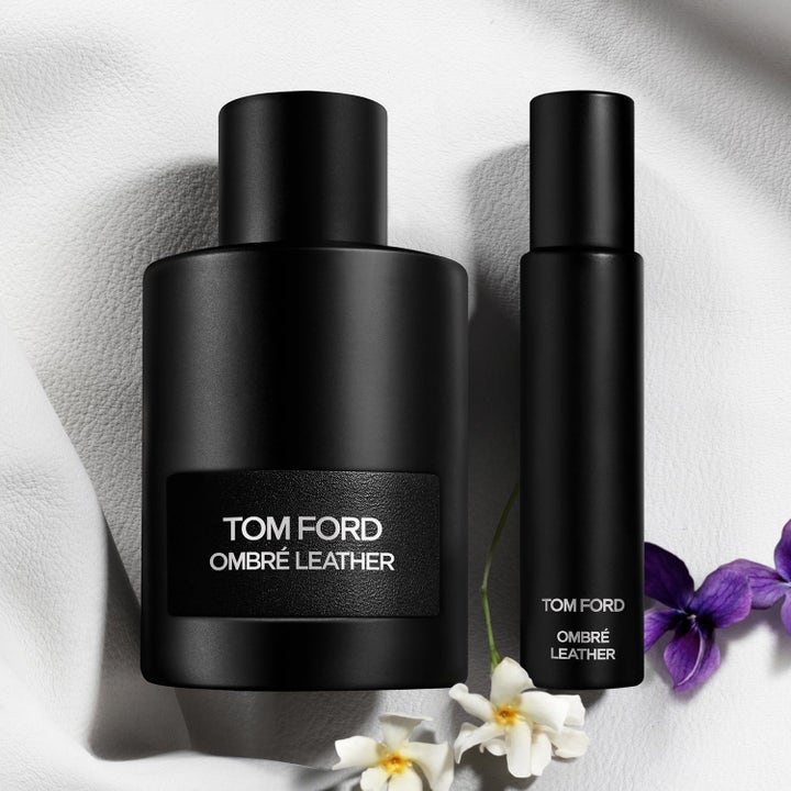 Tom Ford Ombré Leather EdP parfyme og reisespray i matt sort flaske på lyst skinn med blomster