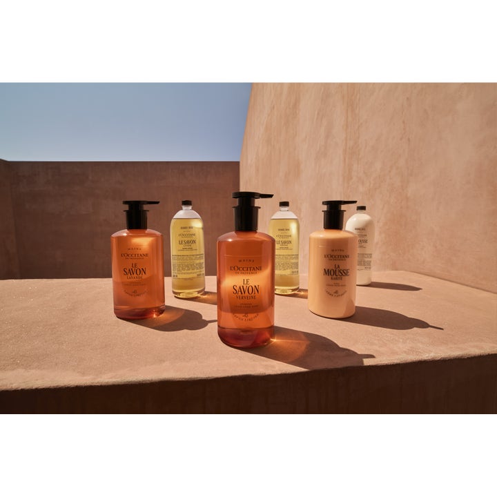 L'Occitane en Provence Shea Cream Hand Wash 500 ml pleiende håndvask i beige flaske og refill på en solfylt murhylle