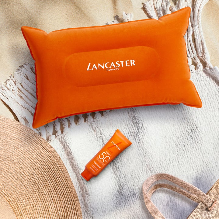 Lancaster Sun Beauty Face Cream 50 ml solkrem med SPF 50 på et strandhåndkle ved en oransje strandpute.