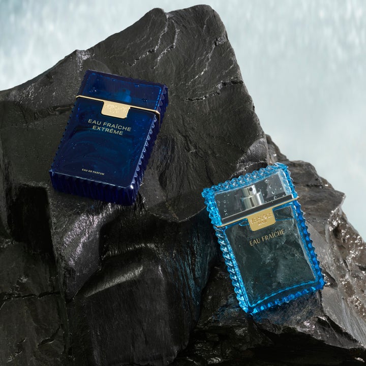Versace Eau Fraiche Extreme Aftershave Balm 100 ml beroligende hudpleie i blå glassflasker på mørke, våte klipper.