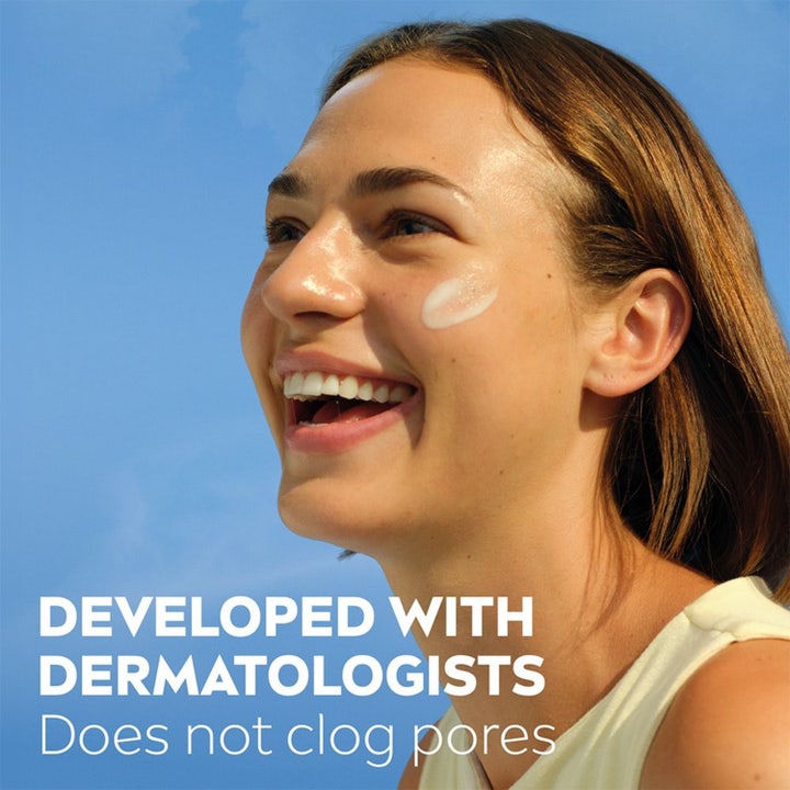 NIVEA UV Face Sensitive Cream SPF 50+ 40 ml solkrem påføres i ansiktet på en smilende kvinne mot blå himmel