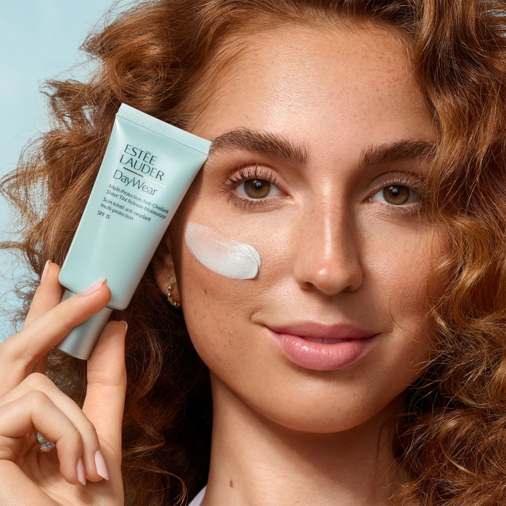 Estée Lauder DayWear Sheer Tint Release Moisturizer 50 ml dagkrem med SPF 15 kvinne som påfører hvit krem fra lysegrønn tube