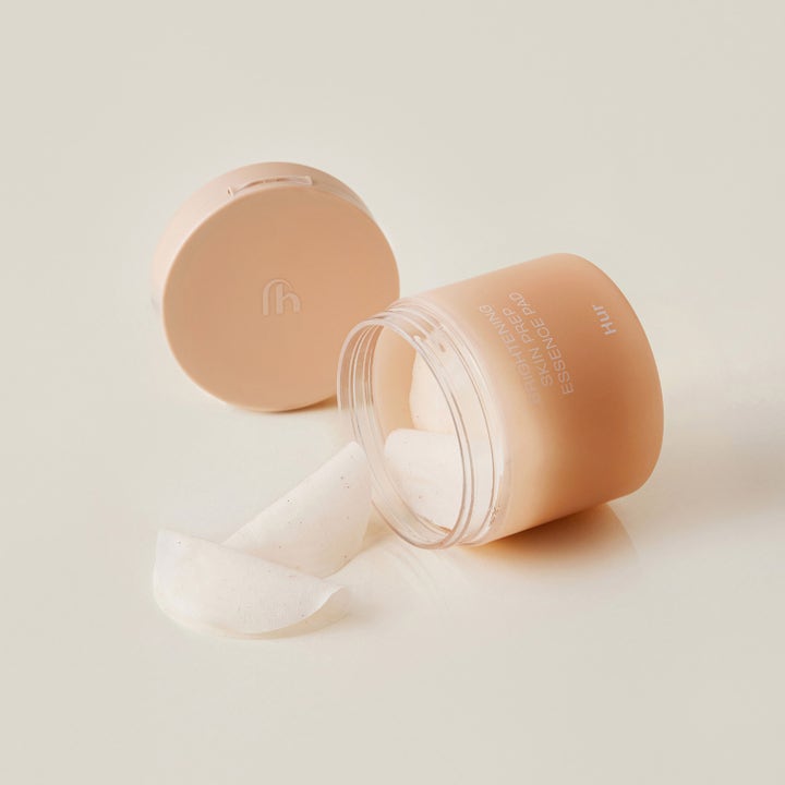 House of Hur Brightening Skin Prep Essence Pad 140 ml glødgivende essence pads som faller ut av en ferskenfarget krukke.
