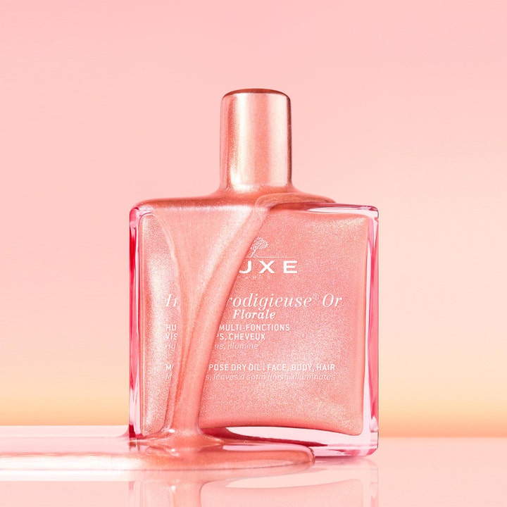 Nuxe Huile Prodigieuse Gold Florale 151 g kroppsolje gir glød med flytende rosa skimmer over glassflasken.