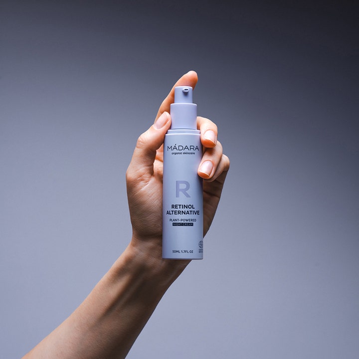 MÁDARA RETINOL ALTERNATIVE 50 ml plantebasert nattkrem i lys lilla pumpeflaske holdt i en hånd