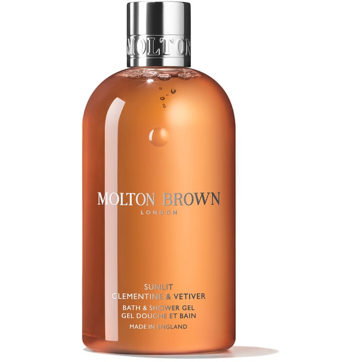 Molton Brown Sunlit Clementine & Vetiver 300 ml dusjsåpe gir en frisk følelse i klar flaske med oransje gel og sølvkork.