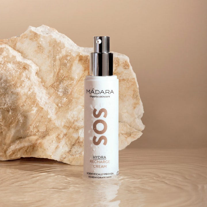 MÁDARA SOS Hydra Recharge Cream 50 ml fuktighetsgivende ansiktskrem i hvit pumpeflaske i vann foran en stein.
