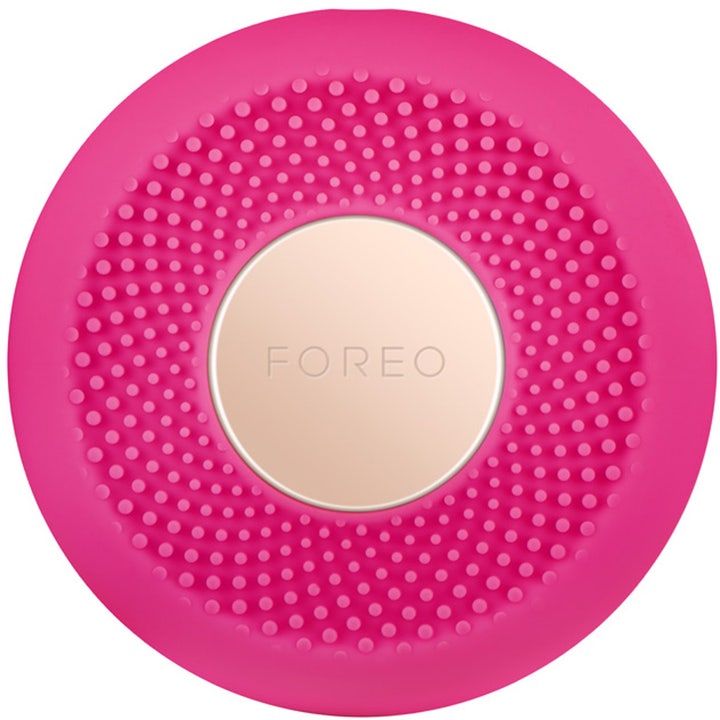 Foreo UFO Mini Fuchsia ansiktsbehandling i silikon gir glød med en rund rosa design og gullfarget midtplate