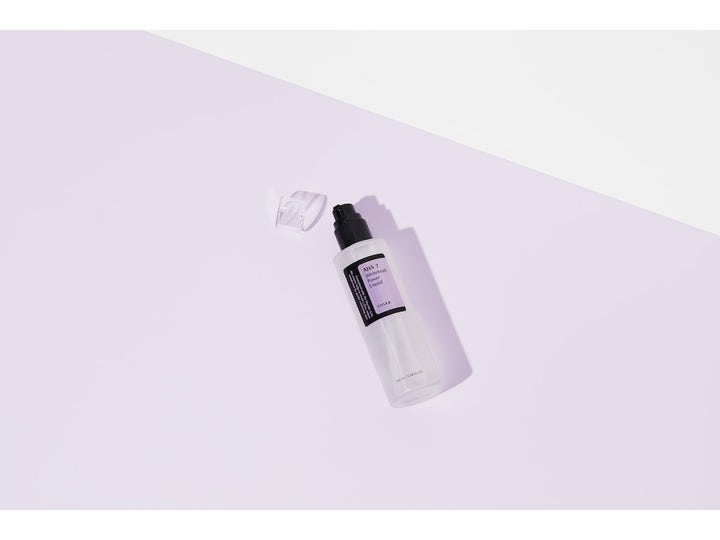 COSRX AHA 7 Whitehead Power Liquid 100 ml eksfolierende toner i frostet flaske med pumpe på lilla bakgrunn