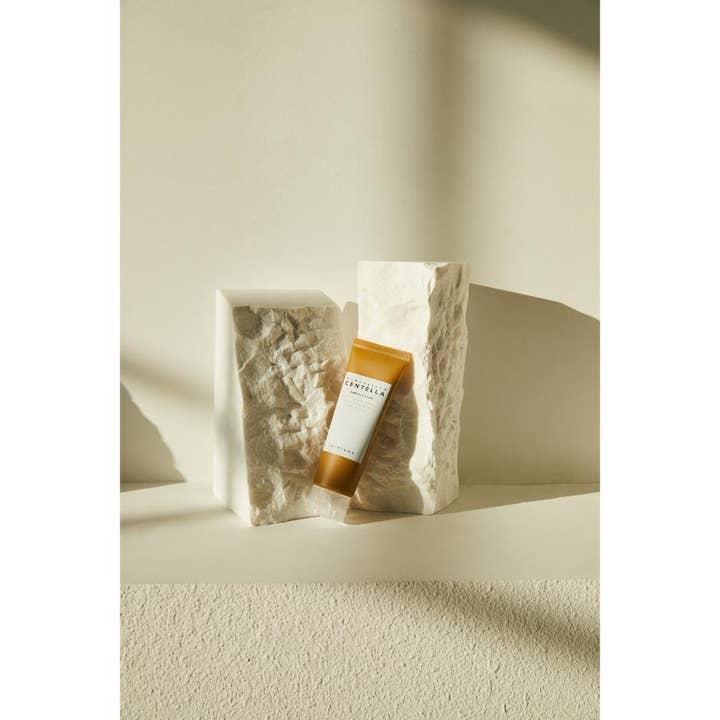 SKIN1004 Madagascar Centella Ampoule Foam 125 ml beroligende renseskum i tube mellom dekorative hvite steiner.