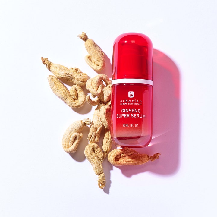 Erborian Ginseng Super Serum 30 ml glattende ansiktsserum i rød pumpeflaske omgitt av tørkede ginsengrøtter.