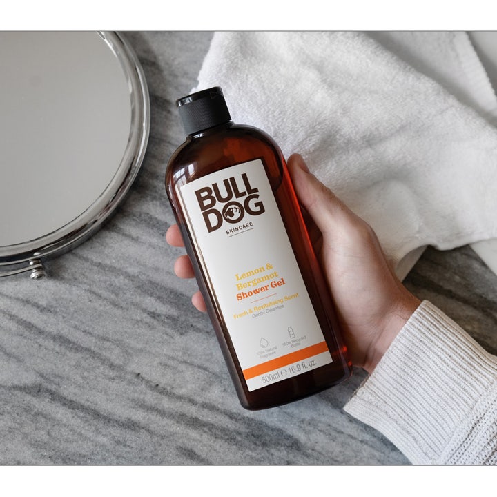 Bulldog Lemon & Bergamot Shower Gel 500 ml frisk dusjsåpe som gir en ren følelse holdt i en hånd ved et speil