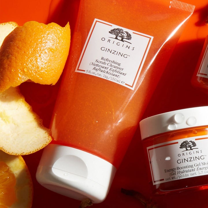 Origins GinZing Refreshing Scrub Cleanser 150 ml eksfolierende rens i oransje tube omgitt av friske appelsinskall