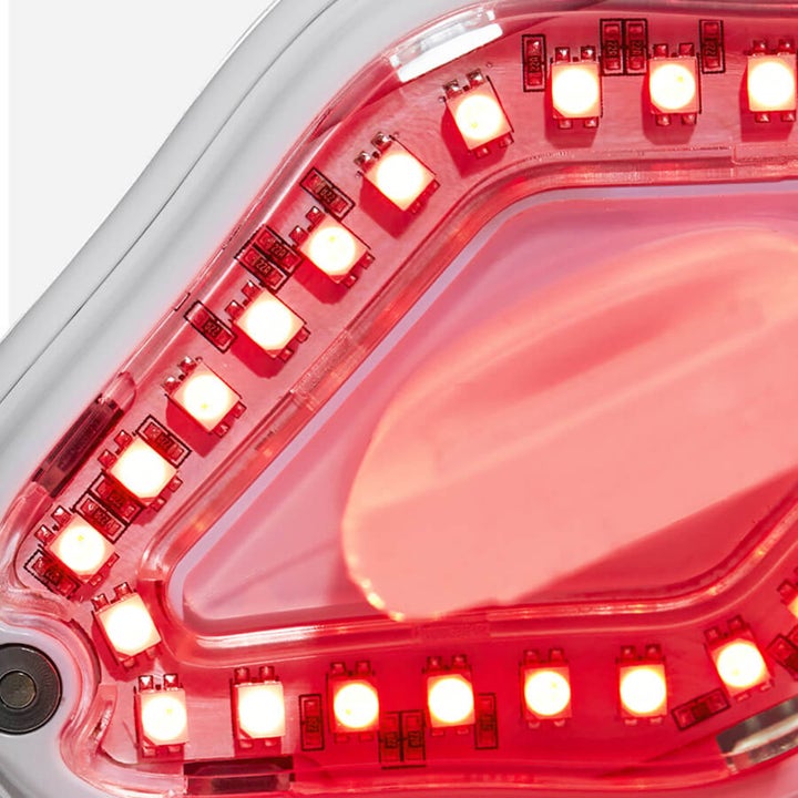 Currentbody Skin LED Lip Perfector hudpleie for fyldigere lepper med nærbilde av røde LED-lys i hvit ramme