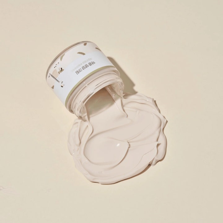 Round Lab Soybean Nourishing Cream 80 ml fuktighetskrem med rik beige tekstur som flyter ut av en glasskrukke.