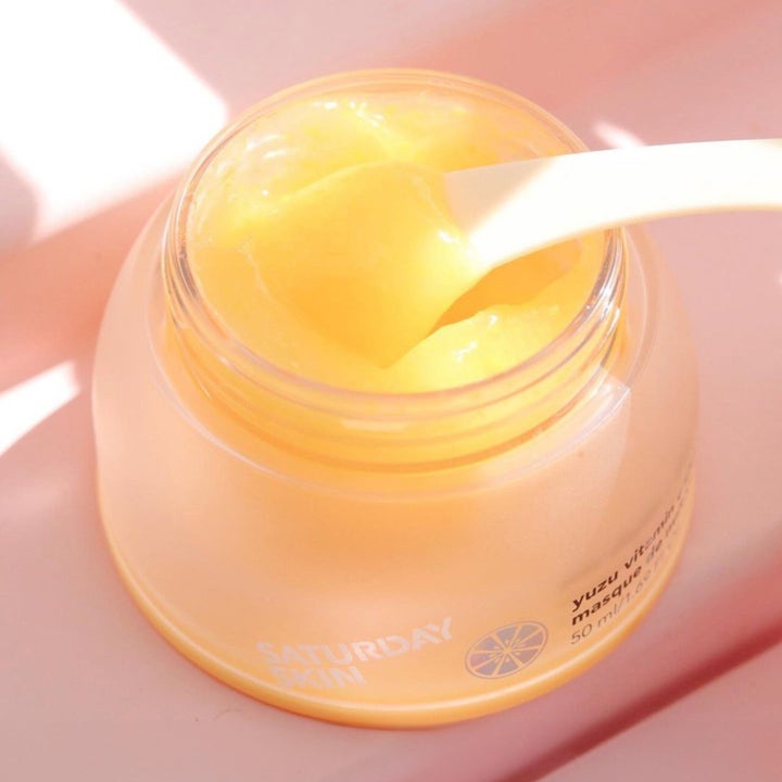 Saturday Skin Yuzu Vitamin C Sleep Mask 50 ml nattmaske med gul gelétekstur i en frostet krukke og hvit spatel.