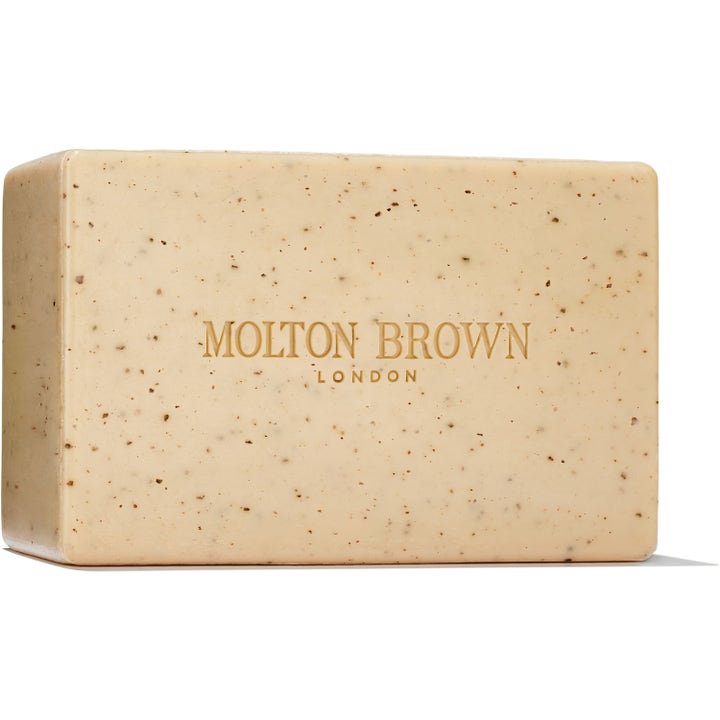 Molton Brown eksfolierende fast såpe for luksuriøs hudpleie i beige farge med mørke korn og preget logo