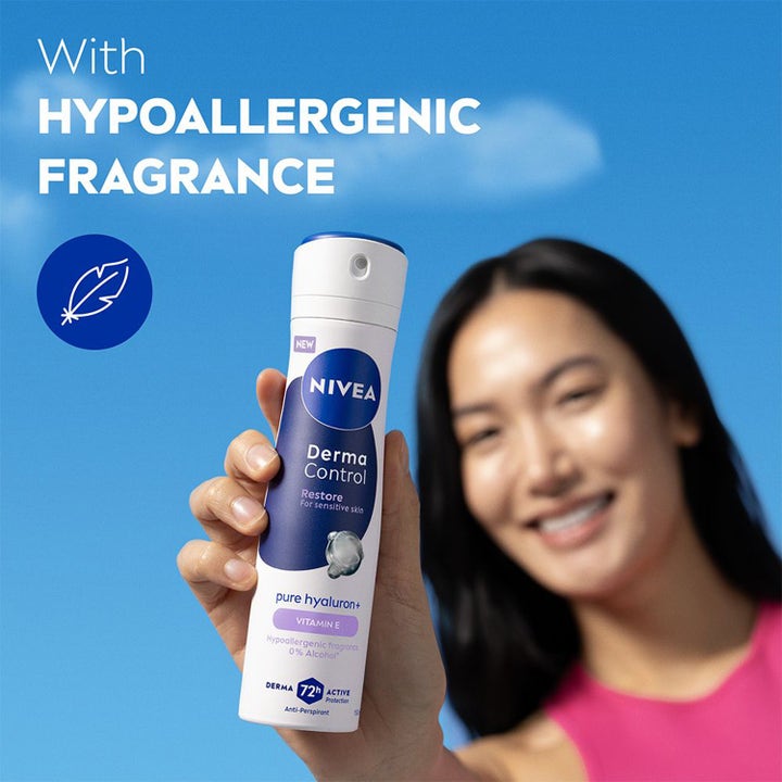 NIVEA Antiperspirant Deo Spray Derma Control Restore 150 ml med allergivennlig duft holdt av kvinne mot blå himmel.