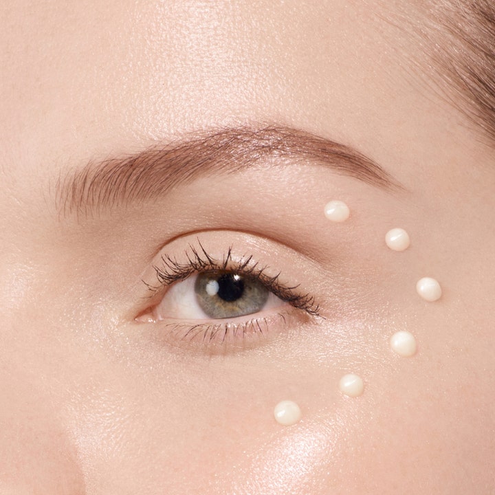 Lancôme Absolue The Eye Cream 20 ml fuktighetsgivende øyekrem vist som små dråper i en bue på huden rundt øyet