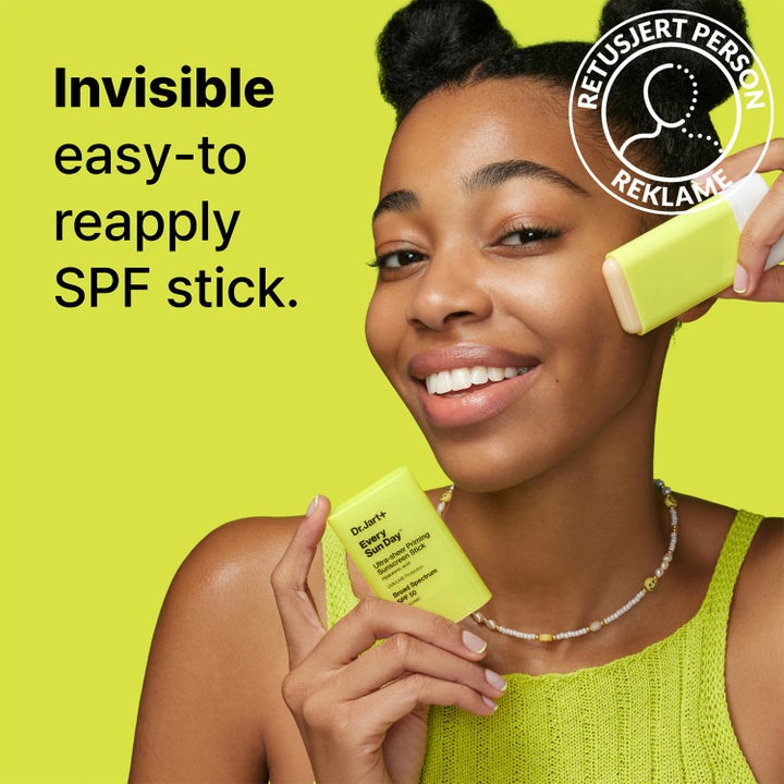 Dr.Jart+ Every Sun Day Sunscreen Stick 19 g gir SPF 50 påføres på huden av en smilende person mot grønn bakgrunn.