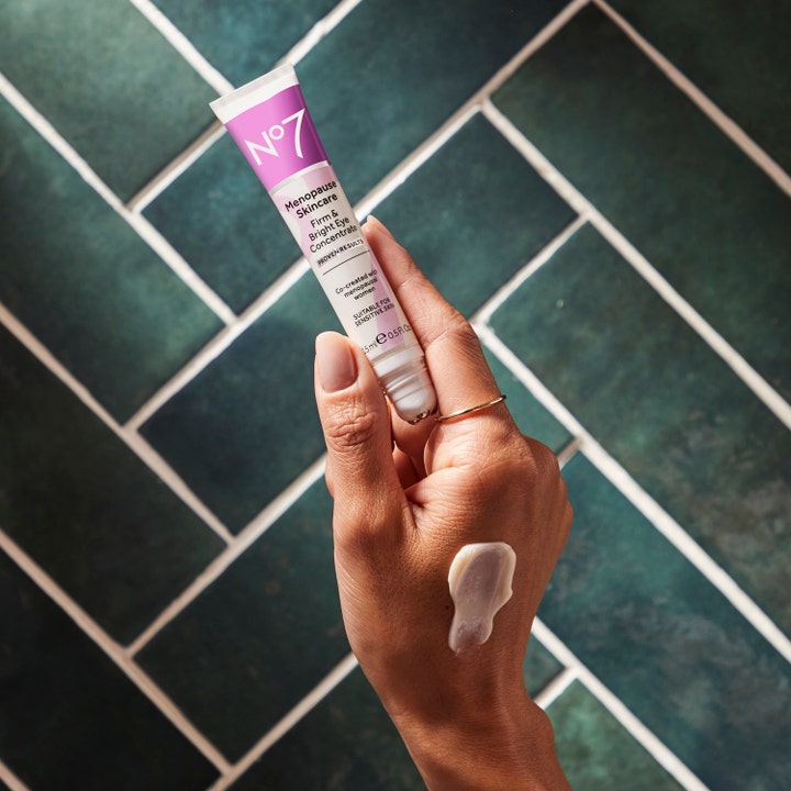 No7 Menopause Skincare Firm & Bright Eye Concentrate 15 ml øyekrem i hvit og lilla tube med kremet tekstur på hånden