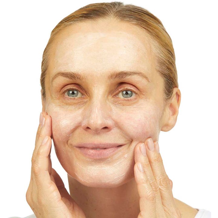 No7 Lift & Luminate Cleansing Exfoliator 100 ml ansiktsrens for glød vist mens den masseres inn i huden