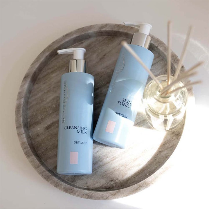 Beauté Pacifique Cleansing Milk 200 ml rengjøringsmelk for tørr hud i lyseblå pumpeflaske på et marmorbrett