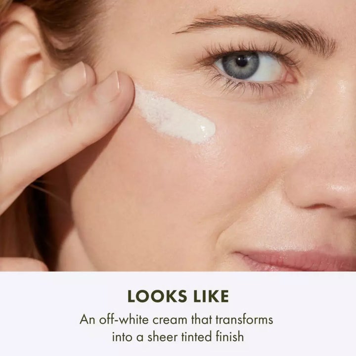 Origins GinZing SPF40 Energy-Boosting Tinted Moisturizer 50 ml energigivende dagkrem i oransje tube holdt av en kvinne