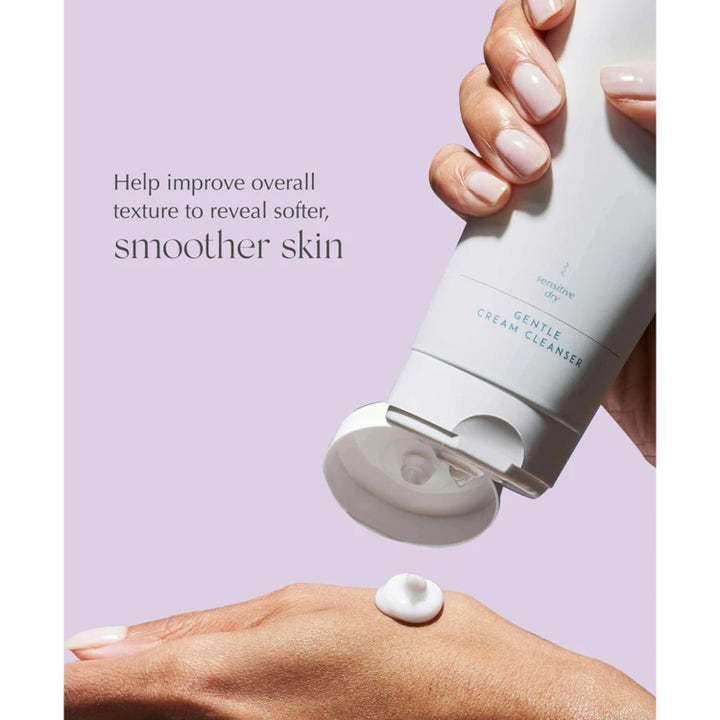 Exuviance Gentle Cream Cleanser 212 ml ansiktsrens for sensitiv hud klemmer ut hvit krem på hånd mot lilla bakgrunn.
