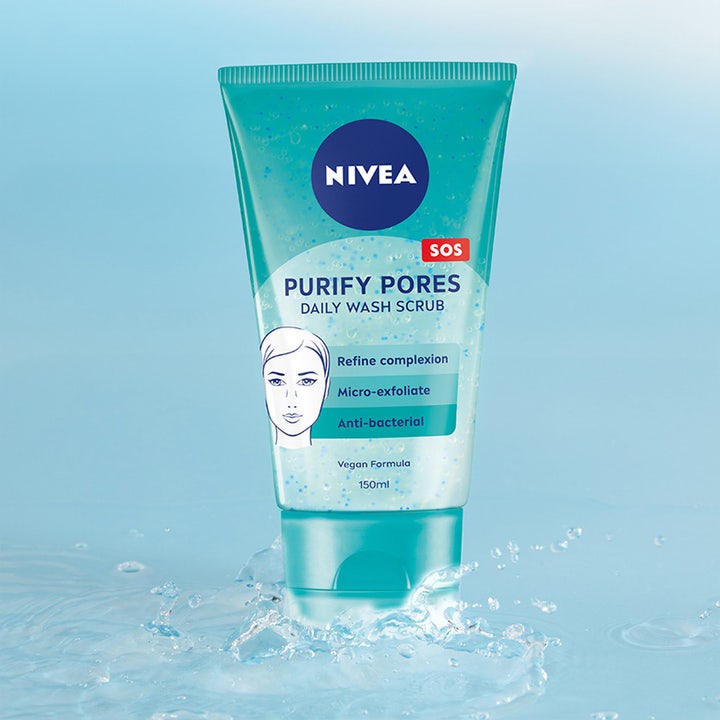 NIVEA Purify Pores Daily Wash Scrub 150 ml antibakteriell ansiktsskrubb i turkis tube omgitt av frisk vannsprut.