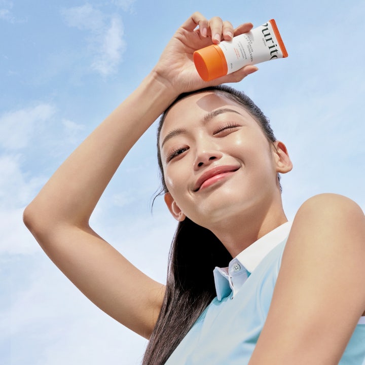 Purito Daily Soft Touch Sunscreen 60 ml beskyttende solkrem i to tuber med oransje korker og svevende hvite kuler
