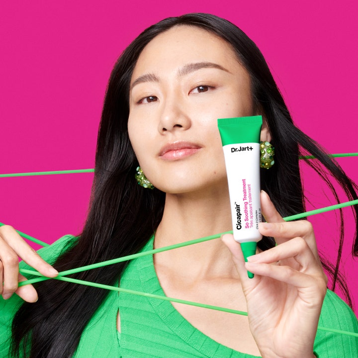 Dr.Jart+ Cicapair So Soothing Treatment 30 ml beroligende ansiktspleie holdt av kvinne mot rosa bakgrunn