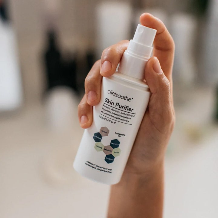 Clinisoothe Skin Purifier Spray 100 ml toner mot uren hud i en hvit sprayflaske som holdes i en hånd.