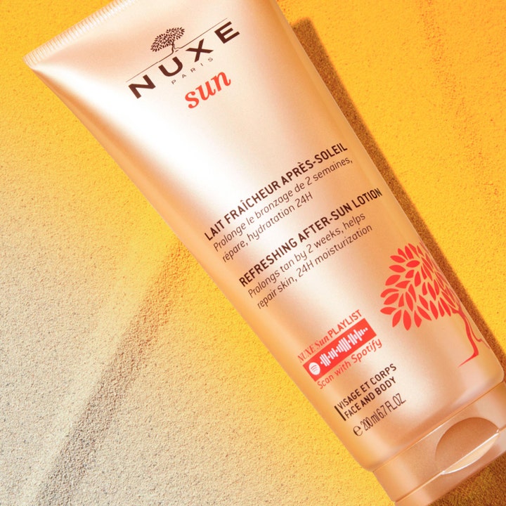 Nuxe Sun Refreshing After Sun Lotion 200 ml fuktighetskrem i bronsefarget tube på gyllen sand
