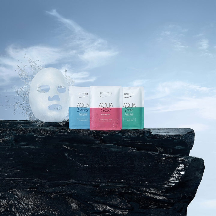 Biotherm Aqua Bounce Flash Mask 35 g fuktighetsgivende ansiktsmaske ved siden av vannsprut på en mørk klippe