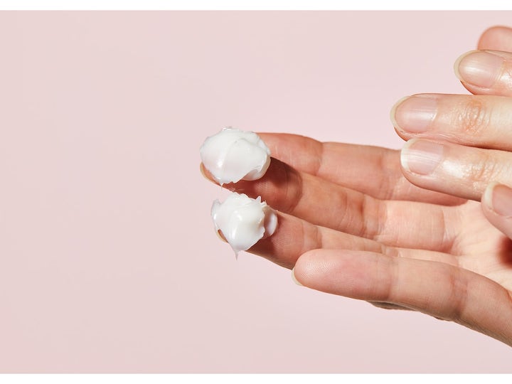 COSRX Balancium Comfort Ceramide Cream 80 ml beroligende ansiktskrem med hvit fyldig tekstur på fingertuppene