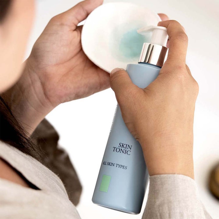 Beauté Pacifique Toner All Skin 200 ml forfriskende ansiktsvann pumpes på en hvit bomullspad fra en lyseblå flaske.