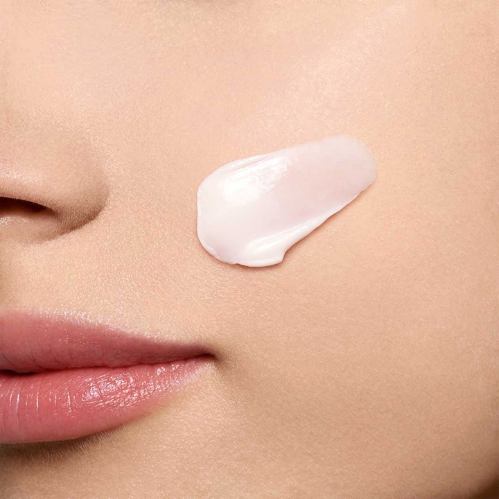 Clarins Super Restorative Day Cream 50 ml gjenoppbyggende dagkrem med en lys rosa kremet tekstur på huden