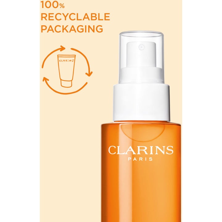 Clarins Glowing Sun Care Mist 150 ml SPF 50 solkrem i oransje sprayflaske med 100% gjenvinnbar emballasje.