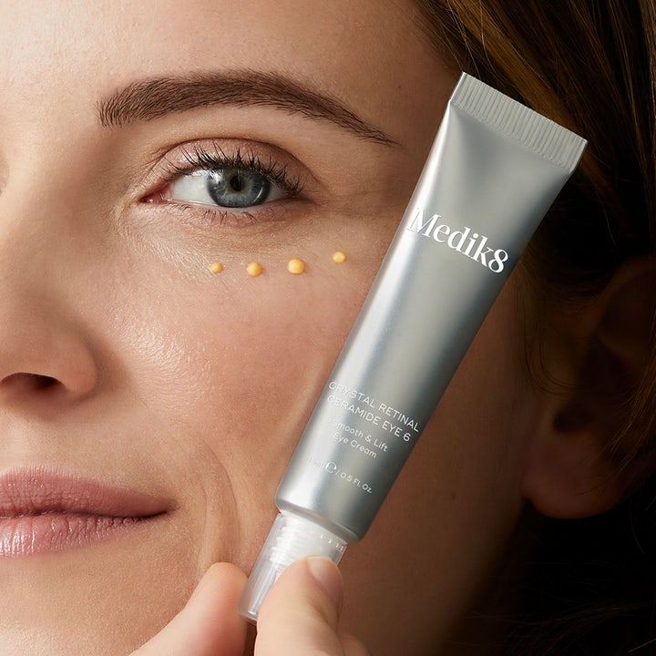 Medik8 Crystal Retinal Ceramide Eye 3 15 ml øyekrem påført som gule prikker under øyet ved en sølvtube