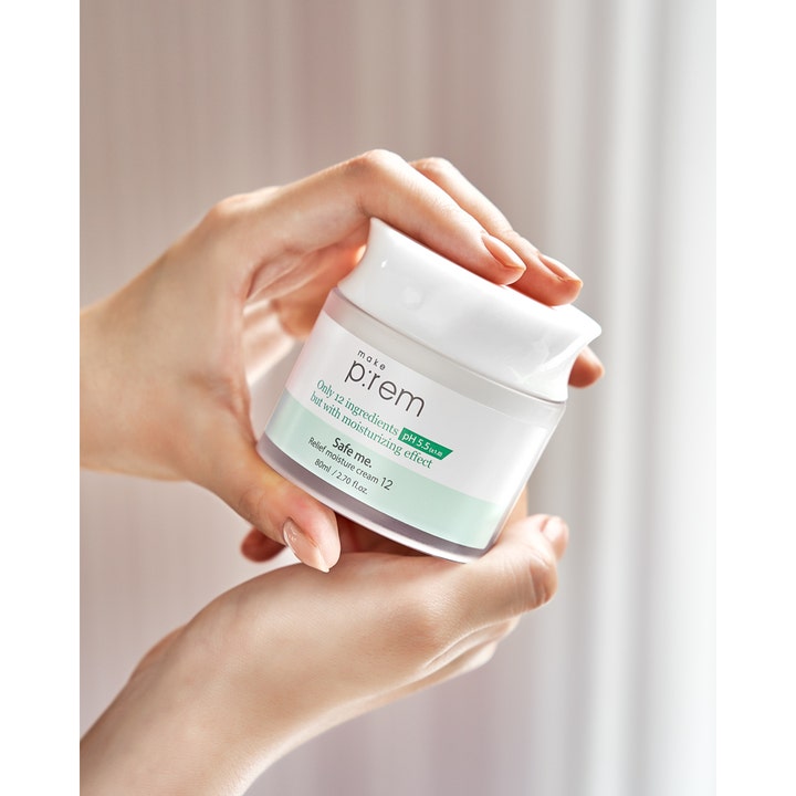 Make Prem Safe Me. Relief Moisture Cream 12 80 ml fuktighetsgivende ansiktskrem i hvit krukke holdt av hender.